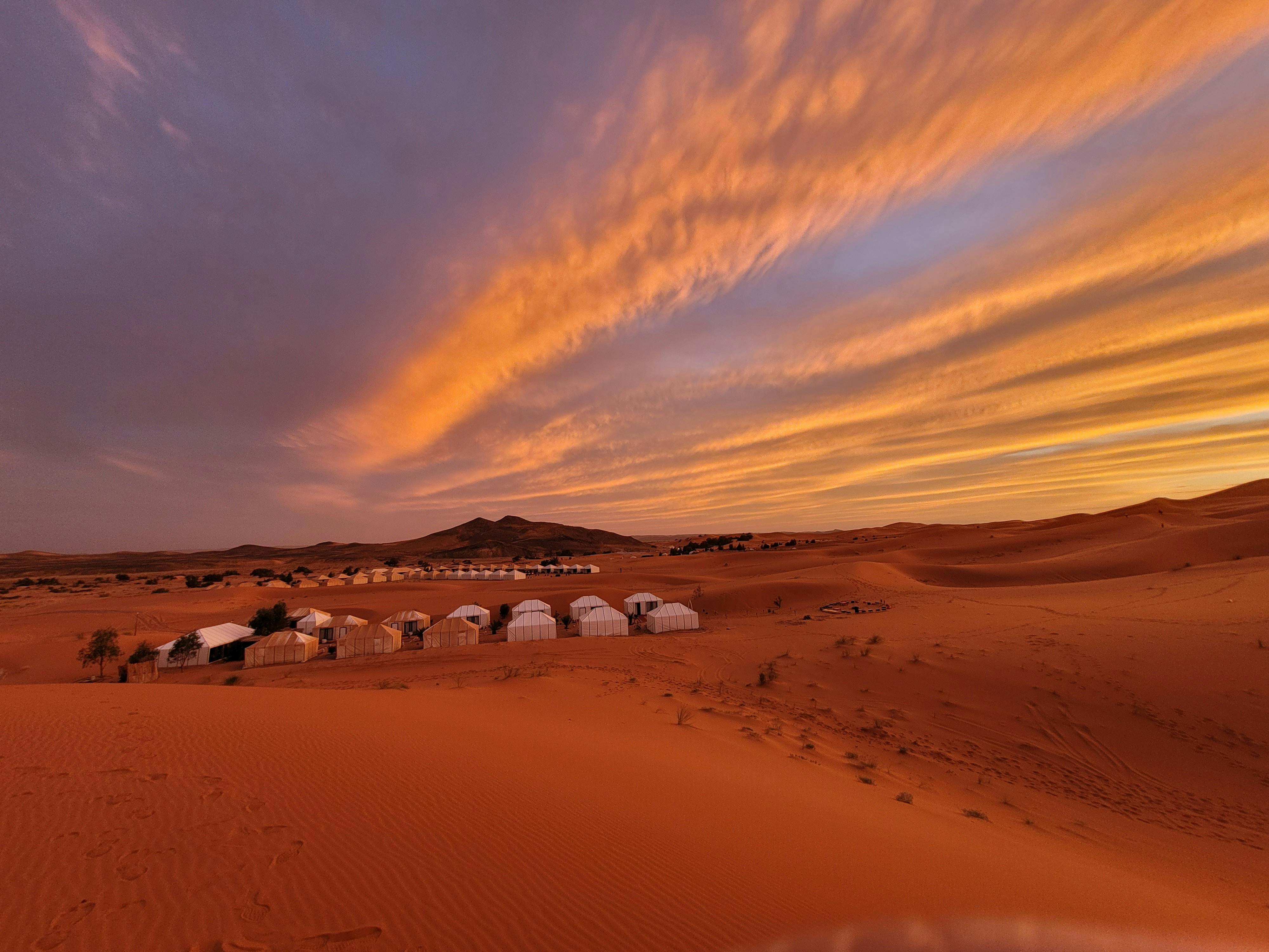 Luxury dinner table setup at sunset in the Agafay rocky desert near Marrakech
